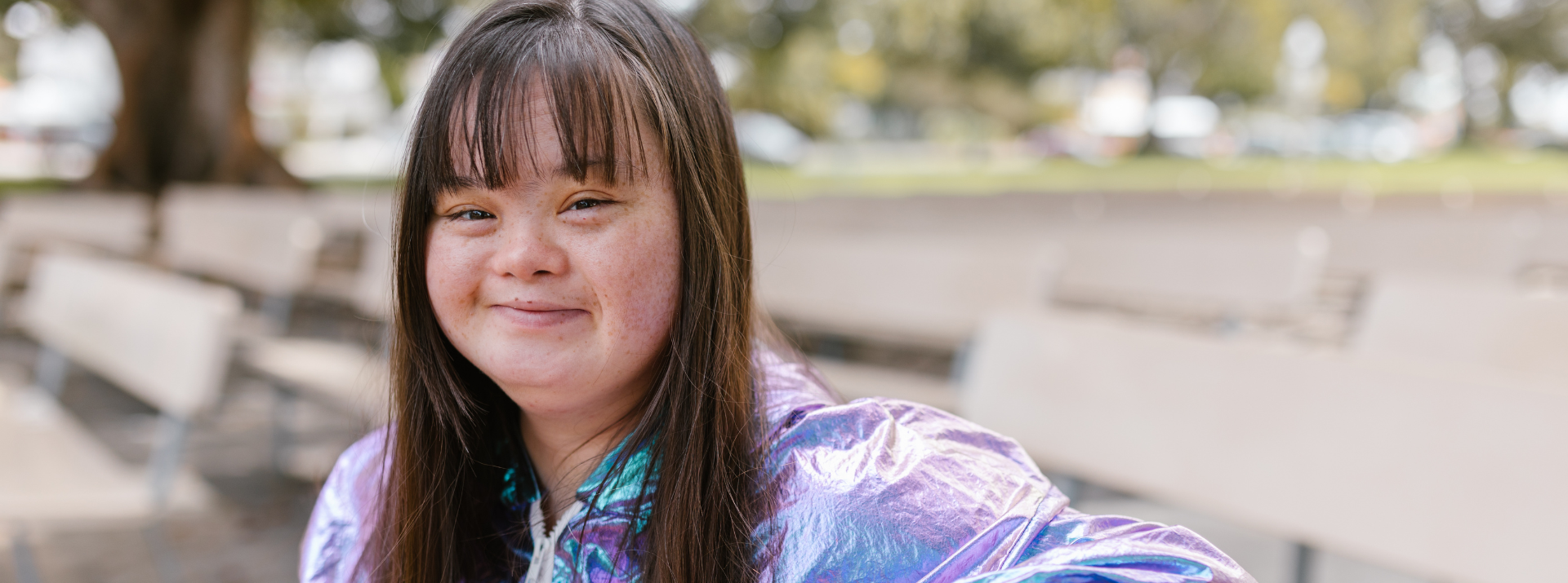 a female child with down syndrome sitting on a bench